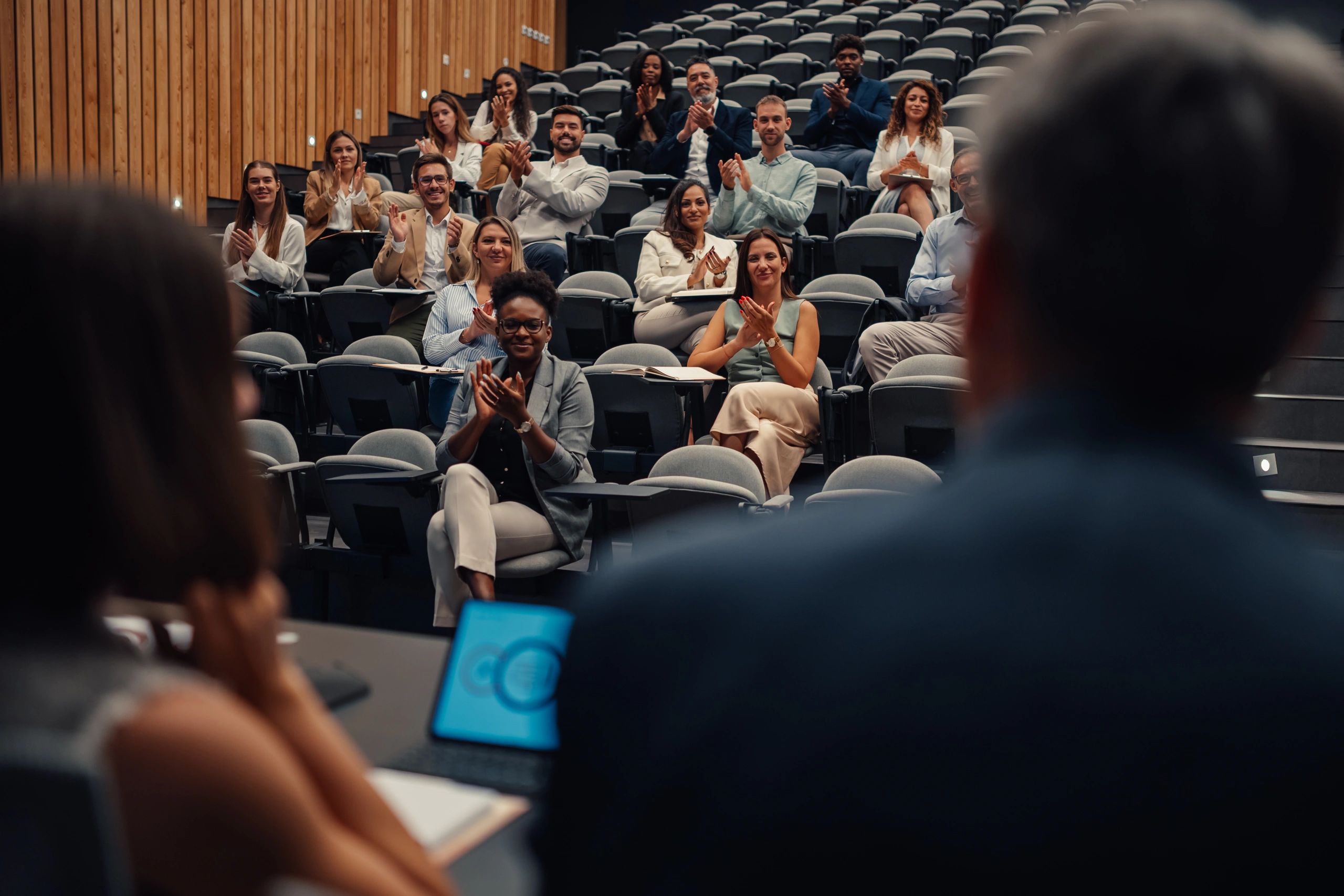 Conference participants applauding during a presentation