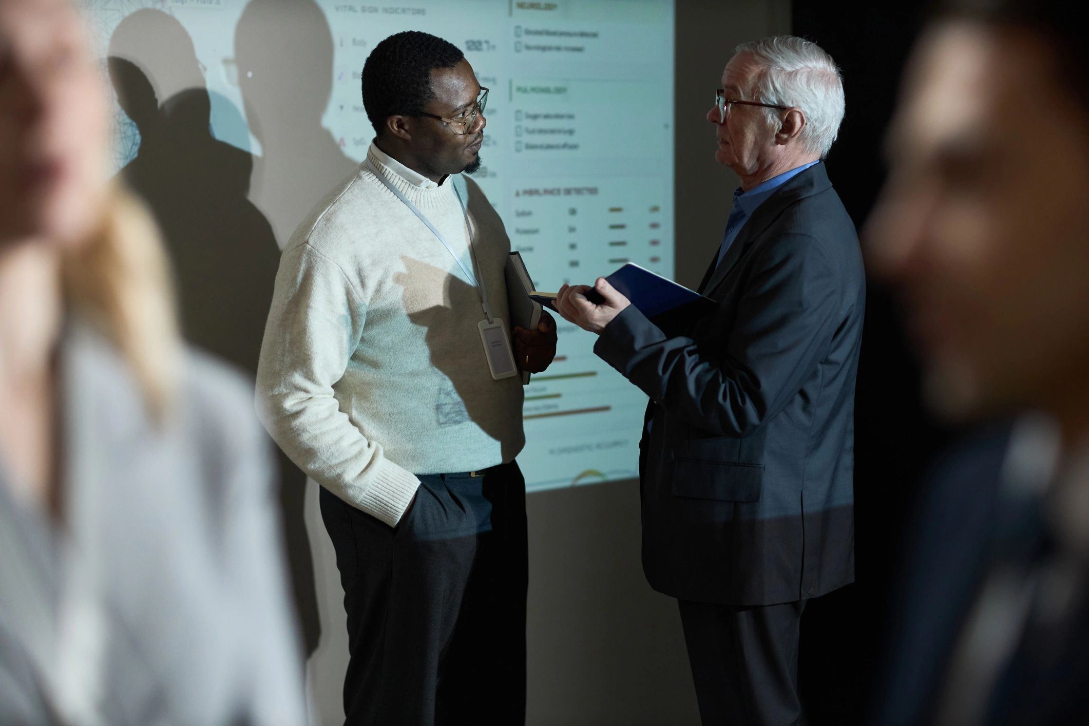 Senior and younger leaders reviewing data together in a meeting